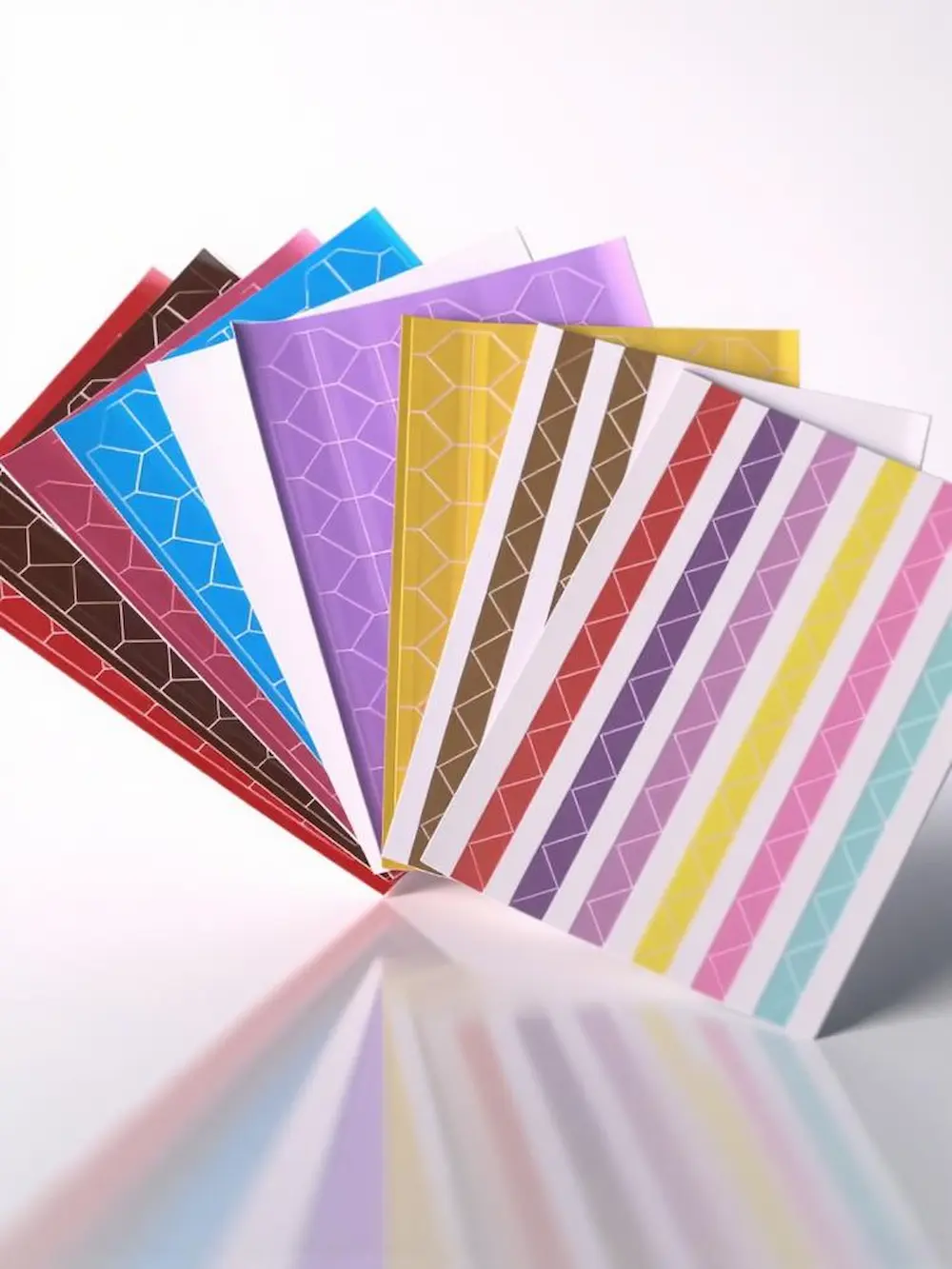 Une collection de feuilles de coins photo décoratifs de diverses couleurs et motifs, disposée en éventail.